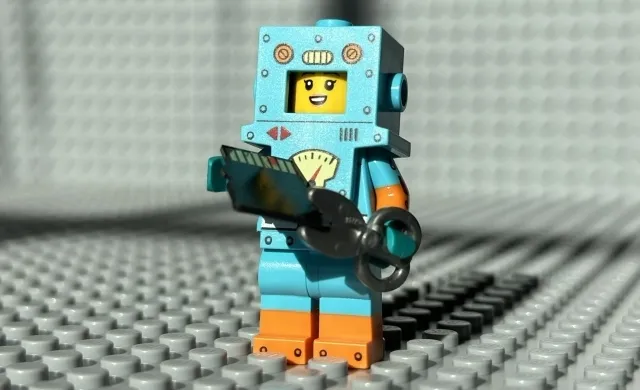 Photo of a LEGO minifigure using a scissor to destroy a microSD card.